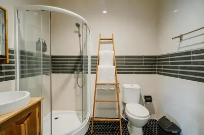 a bathroom with a ladder next to a toilet and a shower at You Suite Seminyak in Legian