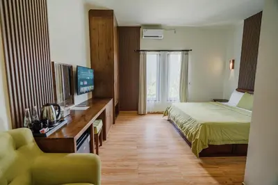 a hotel room with a bed and a television at You Suite Seminyak in Legian