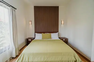 a bedroom with a bed and a large window at You Suite Seminyak in Legian