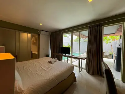 a bedroom with a bed and a balcony with a television at 2 BR Bougenville Villa in Nusa Dua