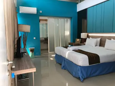 a bedroom with a large bed and a blue wall at 2 BR Bougenville Villa in Nusa Dua