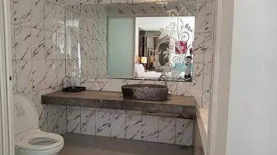 a bathroom with a sink and a toilet and a mirror at 2 BR Bougenville Villa in Nusa Dua