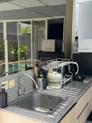 a kitchen sink with a dish drying rack next to it at 2 BR Bougenville Villa in Nusa Dua