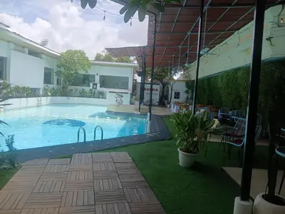 a large swimming pool in a yard with a house at Villa Pool Private and Romantic In Kuta Bali in Kuta