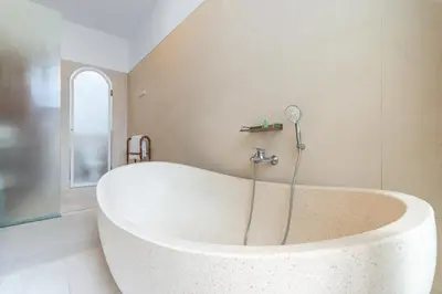 a large white tub in a bathroom with a window at Villa Felicia Canggu By Moria in Canggu