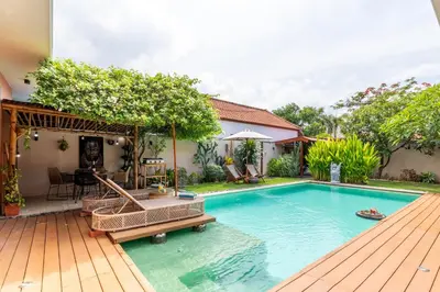 a swimming pool in a backyard with a wooden deck at Villa Santai pour 4 personnes à Seminyak in Seminyak