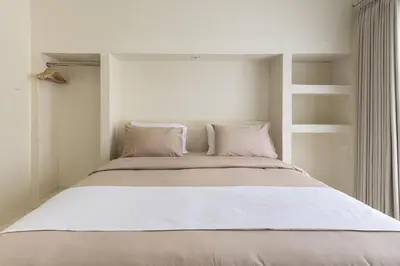 a bed with white pillows in a white bedroom at Casa De La Vida in Legian
