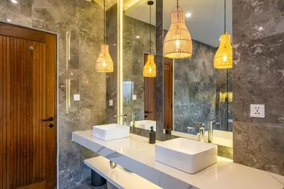 a bathroom with two sinks and two mirrors at Serai Villa by Betterplace in Seminyak