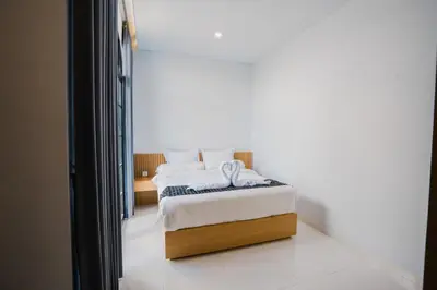 a bedroom with a bed with white sheets at Sari Buana Villa Nusa Dua in Nusa Dua