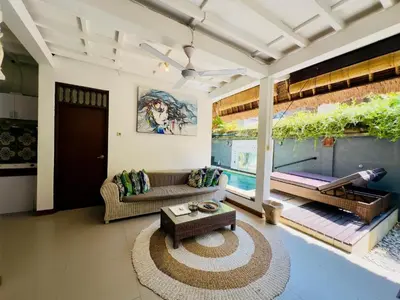 a living room with a couch and a table at Tiga Kelapa Villa by Smart Digital in Legian