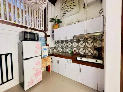a kitchen with white cabinets and a refrigerator at Tiga Kelapa Villa by Smart Digital in Legian