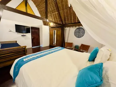 a bedroom with a large bed and a television at Tiga Kelapa Villa by Smart Digital in Legian