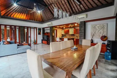 a dining room with a wooden table and chairs at Villa Di Bucu, Canggu in Canggu