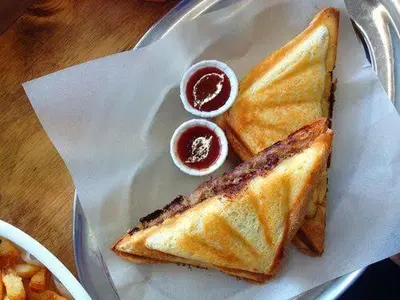 a sandwich on a plate with two dipping sauces at 9 Residences Seminyak in Seminyak