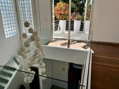 a staircase with a mirror and flowers in a house at 450 квадратных метров, Вид на Рисовое Поле и Лес in Kerobokan
