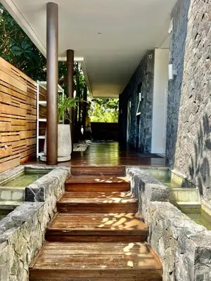 a walkway in a house with a stone wall at 450 квадратных метров, Вид на Рисовое Поле и Лес in Kerobokan