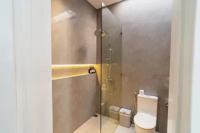 a bathroom with a toilet and a glass shower at Luxury Haven Stunning 2Br in Umalas Canggu in Kerobokan
