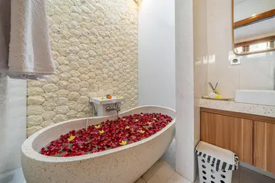 a bathroom with a bath tub filled with red flowers at Umasuka Villa in Denpasar