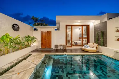 a villa with a swimming pool and a house at Umasuka Villa in Denpasar