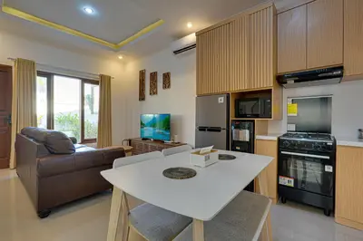 a kitchen and living room with a table and a couch at Villa Taman Seminyak 46 Near Double Six Beach in Seminyak