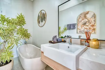 a bathroom with a large white sink and a bath tub at Villa Kangla - 3BR Luxurious Villa Seminyak in Seminyak
