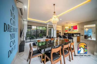 a dining room and living room with a dining table and chairs at SOHO Seminyak 1 - by Unicorn Villas Bali in Seminyak