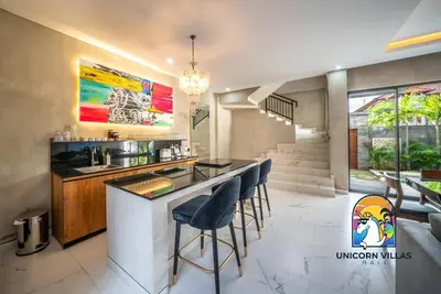 a kitchen with a bar with stools in it at SOHO Seminyak 1 - by Unicorn Villas Bali in Seminyak