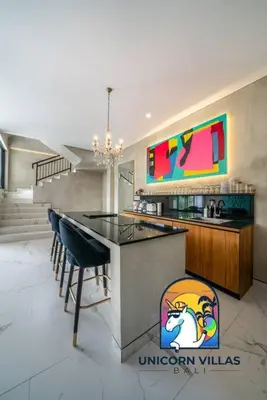 a kitchen with a counter and chairs in a room at SOHO Seminyak 2 - by Unicorn Villas Bali in Seminyak