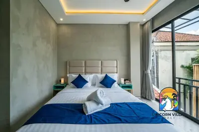 a bedroom with a large bed and a balcony at SOHO Seminyak 2 - by Unicorn Villas Bali in Seminyak