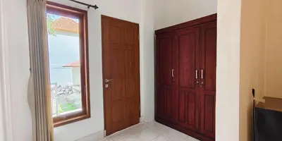 a room with two wooden cabinets and a window at Kusuma Homestay Kerobokan in Kerobokan