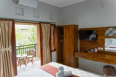 a bedroom with a bed and a balcony at Dara House in Kuta