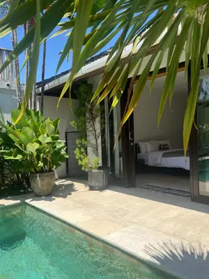 a guest house with a bed and a pool at The Mia Bali in Kerobokan