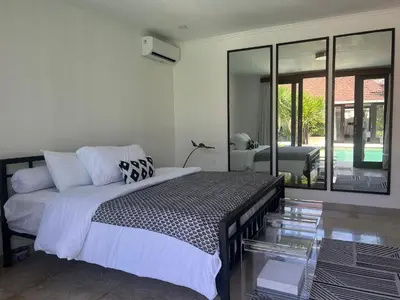 a bedroom with a bed and a glass table at The Mia Bali in Kerobokan