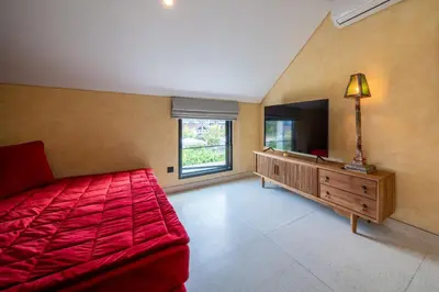 a large room with a red bed and a television at Villa Casa Del Sol Umalas in Kerobokan