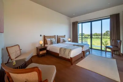 a bedroom with a bed and a large window at Villa Charleston Umalas in Kerobokan