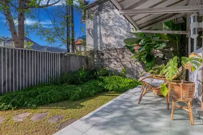 a patio with a table and chairs and a fence at SooBali Mint Cottage Sanur 1BR in Sanur