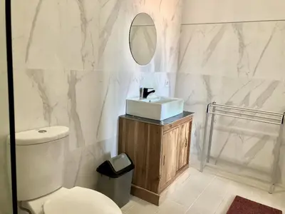 a bathroom with a toilet and a sink and a mirror at Surya Homestay in Seminyak