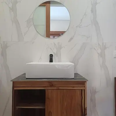 a bathroom with a white sink and a mirror at Surya Homestay in Seminyak