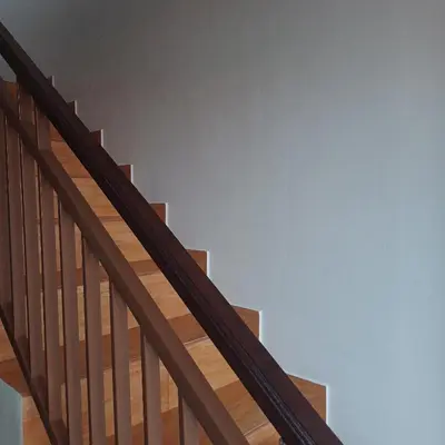 a staircase with wooden railings and a blue wall at Surya Homestay in Seminyak