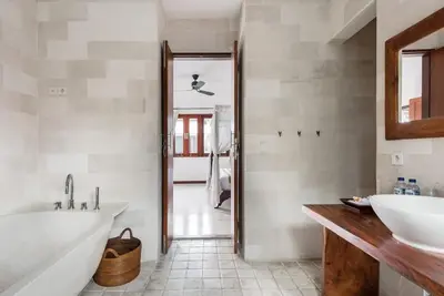 a bathroom with a tub and a sink and a mirror at Villa Annecy in Seminyak