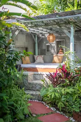 a bed sitting under a pergola in a garden at Jungle Wave Villa in Central Seminyak in Seminyak