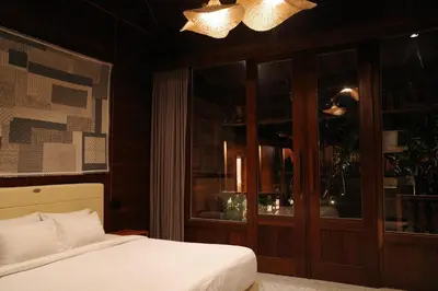 a bedroom with a bed and a chandelier at The Riang Villa in Kerobokan