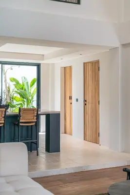 a living room with wooden doors and a table at Villa Moana - Incredible 2BR Villa Next To The Beach in Canggu in Canggu