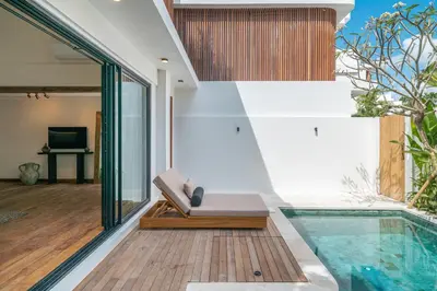 a house with a swimming pool next to a house at Villa Moana - Incredible 2BR Villa Next To The Beach in Canggu in Canggu