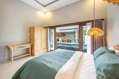 a bedroom with a large bed and a balcony at Q LO 1 , Seminyak in Seminyak