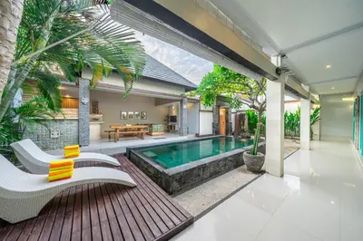 an outdoor patio with a swimming pool and a house at Q LO 1 , Seminyak in Seminyak