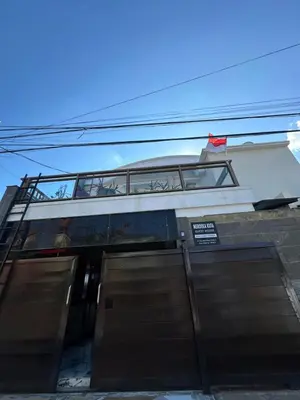 a building with a balcony on top of it at Merdeka Kuta Guesthouse in Legian