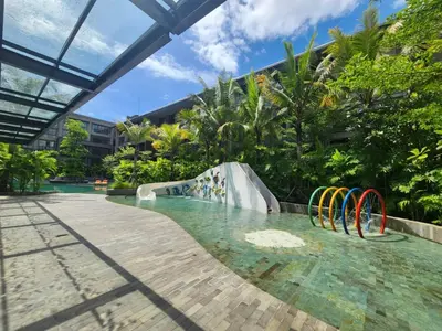 a pool with a water slide in a resort at de' Asasta Apartment Benoa E216 in Nusa Dua