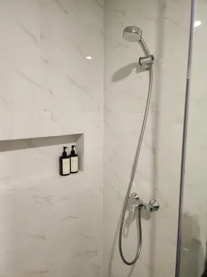 a shower in a bathroom with a glass door at de' Asasta Apartment Benoa E216 in Nusa Dua