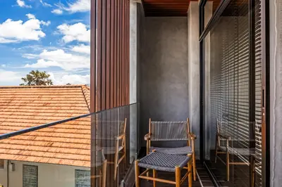 two chairs sitting on the balcony of a house at Aviator Bali in Canggu